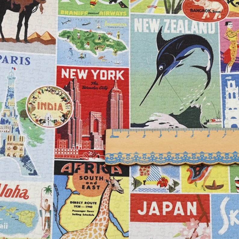 K&ouml;nnte beinhalten: Ein Stoff mit Reisemotiv, der Illustrationen von Wahrzeichen und Reisezielen im Vintage-Stil zeigt. Das Design umfasst Bilder des Eiffelturms, des Empire State Buildings und einer Giraffe mit Textetiketten wie "New York" und "Japan". Ein Holzlineal ist ebenfalls sichtbar.
