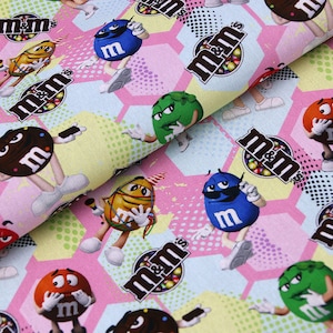 Può includere: Un tessuto rosa e giallo con un motivo ripetuto di personaggi M&M's. I personaggi indossano occhiali da sole e cappelli. Lo sfondo è un motivo a nido d'ape con pois.