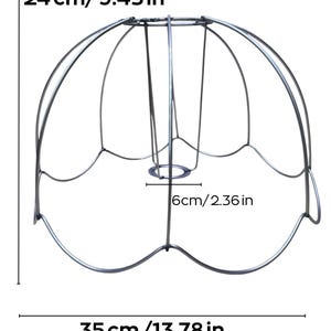 Op de afbeelding: Zilverkleurig lampenkapframe, 35 cm breed, 24 cm hoog en 6 cm in diameter aan de basis. Het frame heeft een bloembladachtig ontwerp, met gebogen metalen staven.