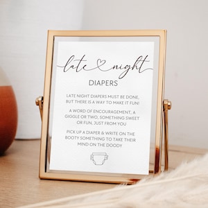 May include: A gold-framed sign with the words "late & night" in elegant script. The sign's text reads "DIAPERS" and includes instructions for writing encouraging messages on diapers. A diaper graphic is at the bottom.