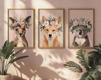 May include: Three framed prints with pink backgrounds feature animal portraits with floral crowns. A kangaroo, a fox, and a koala are depicted with pink and white flowers.
