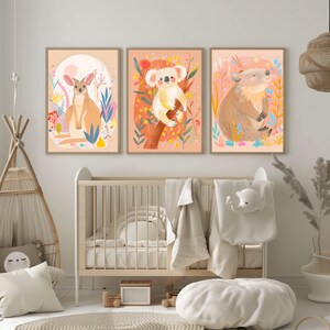 Peut inclure: Trois illustrations encadr&eacute;es d'animaux australiens. La premi&egrave;re montre un kangourou debout dans un champ de fleurs. La deuxi&egrave;me montre un koala assis sur une branche avec des fleurs. La troisi&egrave;me montre un wombat assis dans un champ de fleurs.