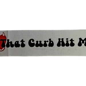 May include: A white sticker with a red heart with devil horns and a tail. The text "That Curb Hit Me" is in black, stylized font.