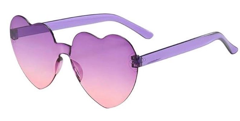May include: Heart-shaped sunglasses featuring rimless lenses with a gradient transition from a deep purple at the top to a soft pink at the bottom. The frames include translucent purple plastic temples and a matching bridge connecting the two lenses.