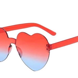 May include: Heart-shaped sunglasses featuring a rimless design with a gradient lens transition. The lenses shift from a vibrant red at the top to a light blue at the bottom. The frame arms are made of a matching translucent red plastic material.