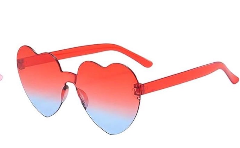 May include: Heart-shaped sunglasses featuring a rimless design with a gradient lens transition. The lenses shift from a vibrant red at the top to a light blue at the bottom. The frame arms are made of a matching translucent red plastic material.