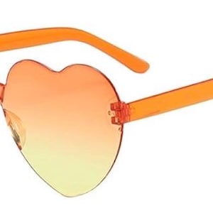 May include: Heart-shaped sunglasses featuring a rimless design with a gradient lens transition from orange at the top to yellow at the bottom. The frames include translucent orange plastic temples and a matching bridge connecting the two lenses.