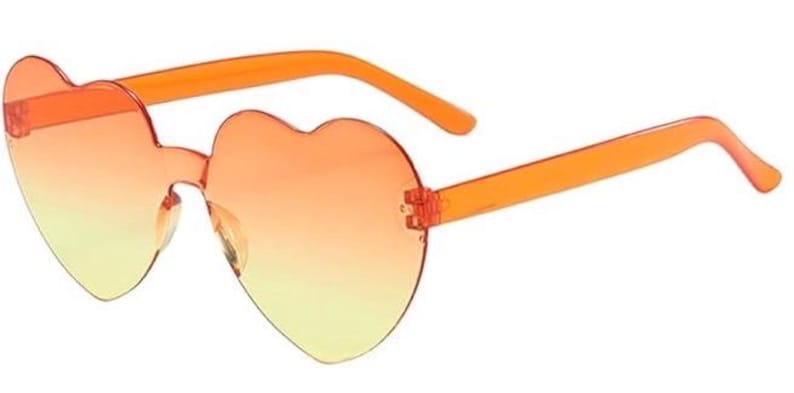 May include: Heart-shaped sunglasses featuring a rimless design with a gradient lens transition from orange at the top to yellow at the bottom. The frames include translucent orange plastic temples and a matching bridge connecting the two lenses.