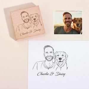 May include: A wooden stamp with a black and white line drawing of a man and a dog. The text "Charlie & Daisy" is engraved on the stamp.