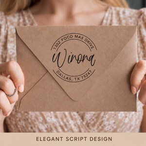May include: A brown envelope with a circular stamp featuring the name "Winona" in elegant script. The stamp also includes the address "1302 Poco Mas Drive, Dallas, TX 75247". The words "ELEGANT SCRIPT DESIGN" are at the bottom.