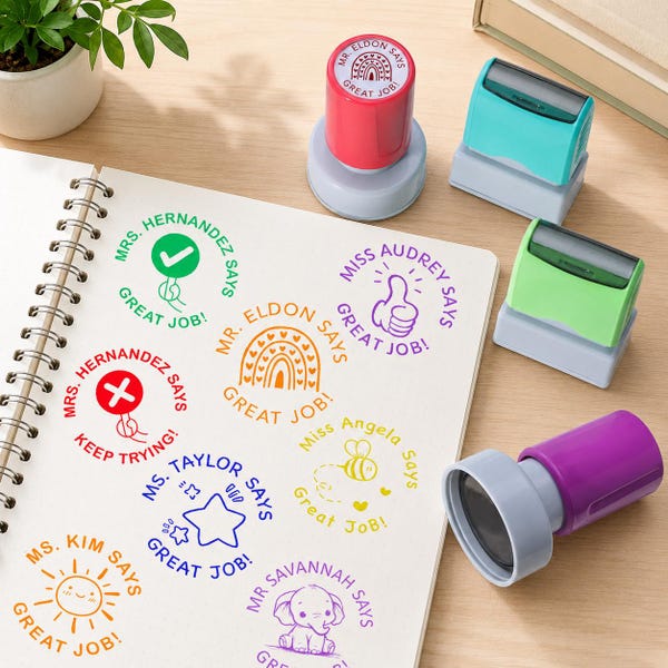 Puede incluir: Una colección de coloridos sellos para profesores y un cuaderno de espiral. Los sellos son de varios colores, incluyendo rojo, verde y morado, con "Great Job!" y nombres de profesores. El cuaderno muestra diseños estampados con mensajes positivos e ilustraciones bonitas.