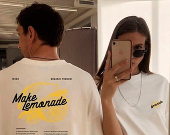 May include: White t-shirt with a yellow graphic that says "Make Lemonade" and includes instructions on how to make lemonade. The back of the shirt has a smaller yellow graphic that says "Lemonade".