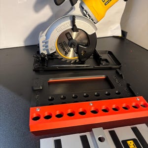 May include: A black and yellow DeWalt 20V MAX cordless circular saw with a 4-1/2 inch blade. The saw is mounted on a black and red guide track system with a black and red guide rail.