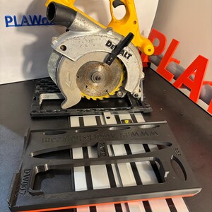 May include: A yellow and silver circular saw with a black base and blade guard. The saw is a DeWalt model. A black and orange guide is in front of the saw. The guide has the text "WWW.PLAwesomedesigns.com" and "DW007".