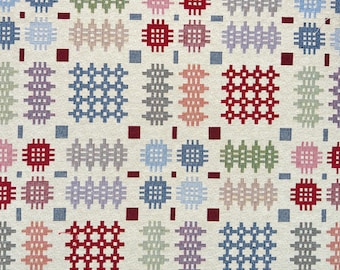 Puede incluir: Un primer plano de una tela tejida con un patrón repetitivo de cuadrados coloridos. Los cuadrados están hechos de hilos de diferentes colores, creando un diseño geométrico. La tela es beige con cuadrados rojos, azules, verdes y morados.