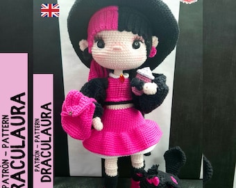 May include: Crochet doll with black hair and pink and black clothing. The doll is wearing a witch's hat and holding a small cup. The doll is standing next to a small black crochet cat.
