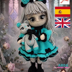 Pode incluir: Uma boneca de crochê feita à mão com longos cabelos cinzentos, vestindo um vestido turquesa com acabamento preto e botas pretas. A boneca tem olhos grandes e pretos e segura um pequeno urso de peluche cinzento com detalhes em turquesa.