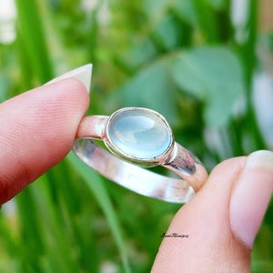 以下が含まれることがあります： 薄い青色の楕円形の宝石が付いた銀の指輪