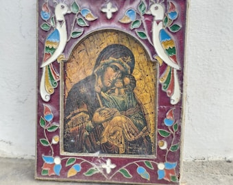 May include: A rectangular religious icon featuring a depiction of the Virgin Mary and child. The icon is framed with a burgundy border, adorned with colorful floral and bird motifs. The text "Holy Land Merchandise" is at the bottom.