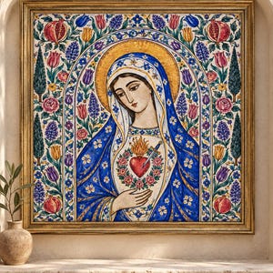 May include: A framed square wall art piece featuring a central figure of a woman with a blue head covering and a red heart pierced by a sword on her chest. The border is decorated with colorful pomegranates, tulips, and roses on a white background.