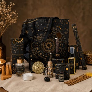 Puede incluir: Una colección de artículos de temática celestial en negro y oro que incluye una caja grande, una tela, un frasco de perfume de vidrio con la etiqueta Jasmine & Oud, un frasco pequeño con hierbas secas, un aceite esencial, un spray e incienso.