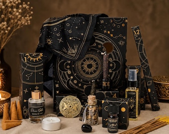 May include: A collection of black and gold celestial-themed items including a large box, a fabric wrap, a glass perfume bottle labelled Jasmine & Oud, a small glass jar with dried herbs, a black essential oil bottle, a spray bottle, and incense sticks.