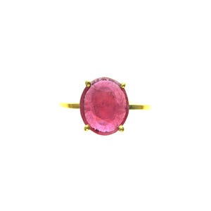 May include: A gold ring featuring a large, oval-cut, pink gemstone. The gemstone is held in place by four prongs. The ring band is a simple, thin gold band. The ring is set against a white background.
