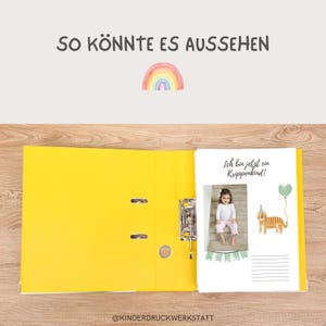 May include: A yellow binder with a white page showing a photo of a child with a rainbow and the text "Ich bin jetzt ein Krippenkind!" (I am now a nursery child!).