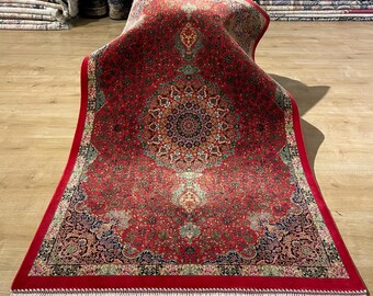 May include: A vibrant red Persian rug with an intricate central medallion design and detailed floral patterns. The rug features a red border and white fringe. Other rugs are visible in the background.