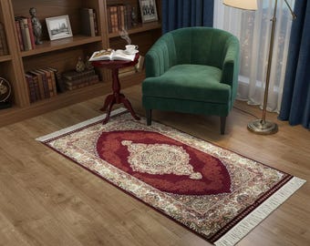 May include: A rectangular area rug with a central oval design in burgundy, cream, and gold tones. The rug features an intricate floral pattern and a fringed border, placed on a hardwood floor.