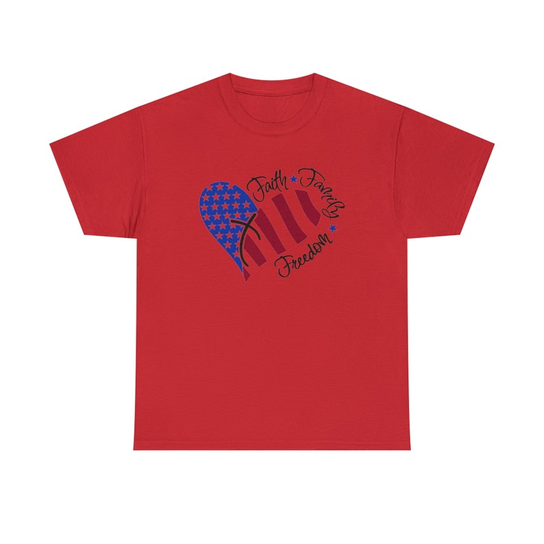 Puede incluir: Camiseta roja con un dise&ntilde;o en forma de coraz&oacute;n que presenta una bandera estadounidense y las palabras "Fe, Familia, Libertad".