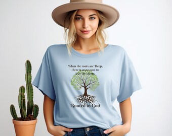 May include: A light blue t-shirt with a graphic of a tree with deep roots and the text "When the roots are Deep, there is no reason to fear the storm. Rooted in God".