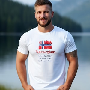 May include: White t-shirt featuring the Norwegian flag and the text "Norwegians have FAULTS but BEING WRONG isn't one of them." The design is in red, white, and blue. The shirt is worn by a person.