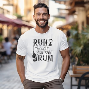 May include: White t-shirt with a black graphic that says "RUN? I thought you said RUM" with a bottle of rum and a pirate hook.