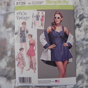 Op de afbeelding: Een Simplicity naaipatroon envelop 8139 met kleding in 1950s vintage stijl. De omslag toont illustraties en een foto van een donkerblauwe jurk met stippen en een strikdetail, gecombineerd met een lichtgekleurd jasje. Tekst bevat 1950s Vintage.