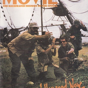 May include: Cover of "The Movie" magazine, issue 84, featuring a film crew on a movie set. The cover art includes the title in orange, the tagline "The Illustrated History of the Cinema," and the words "Hollywood Now" in orange.