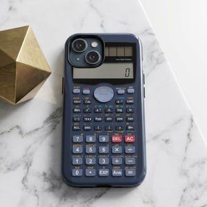 May include: A dark blue smartphone case designed to resemble a scientific calculator, featuring a digital display showing zero, a solar panel, and a full grid of multi-colored buttons with mathematical symbols and functions printed on the surface.