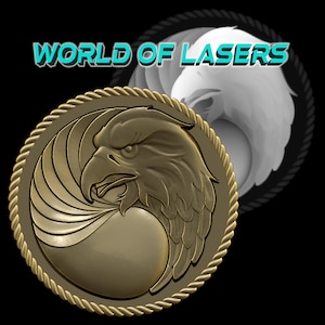 May include: A gold-colored metal coin with a raised design of an eagle's head and wings. The coin is surrounded by a rope-like border. The text "WORLD OF LASERS" is visible in the background.