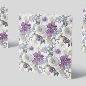 May include: A seamless pattern featuring watercolour purple and white flowers on a white background. The flowers are arranged in a random pattern and are surrounded by green leaves.