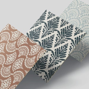 Puede incluir: Tres hojas de papel con patrones diferentes. La primera hoja tiene un patrón paisley marrón y blanco. La segunda hoja tiene un patrón de hojas azul oscuro y blanco. La tercera hoja tiene un patrón geométrico azul claro y blanco.