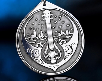 May include: A silver pendant necklace featuring a detailed mandolin design within a circular frame. The pendant showcases a cityscape and birds, suspended from a black cord. The intricate design is suitable for music lovers.