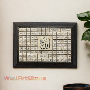 May include: A framed black and gold Islamic art print with a white background. The print features a grid of Arabic calligraphy with the word "Allah" in the center.