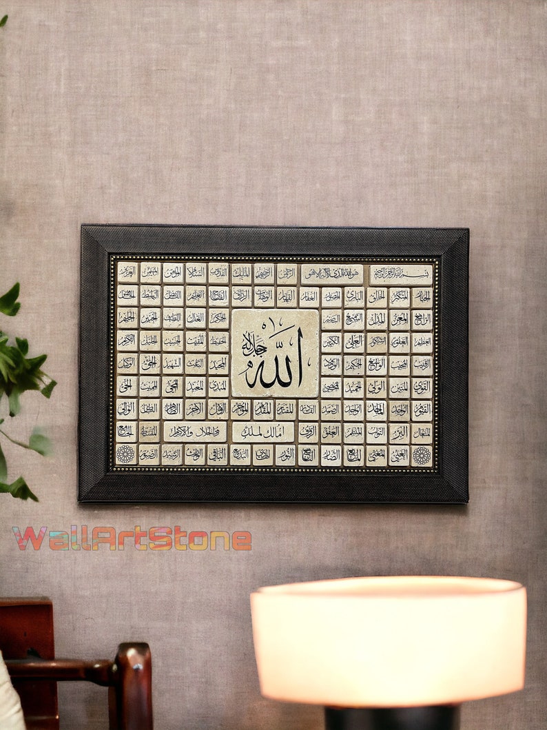 May include: A framed black and gold Islamic art print with the word "Allah" in Arabic script surrounded by 99 names of God in Arabic. The print is on a beige background and has a black frame with gold accents.