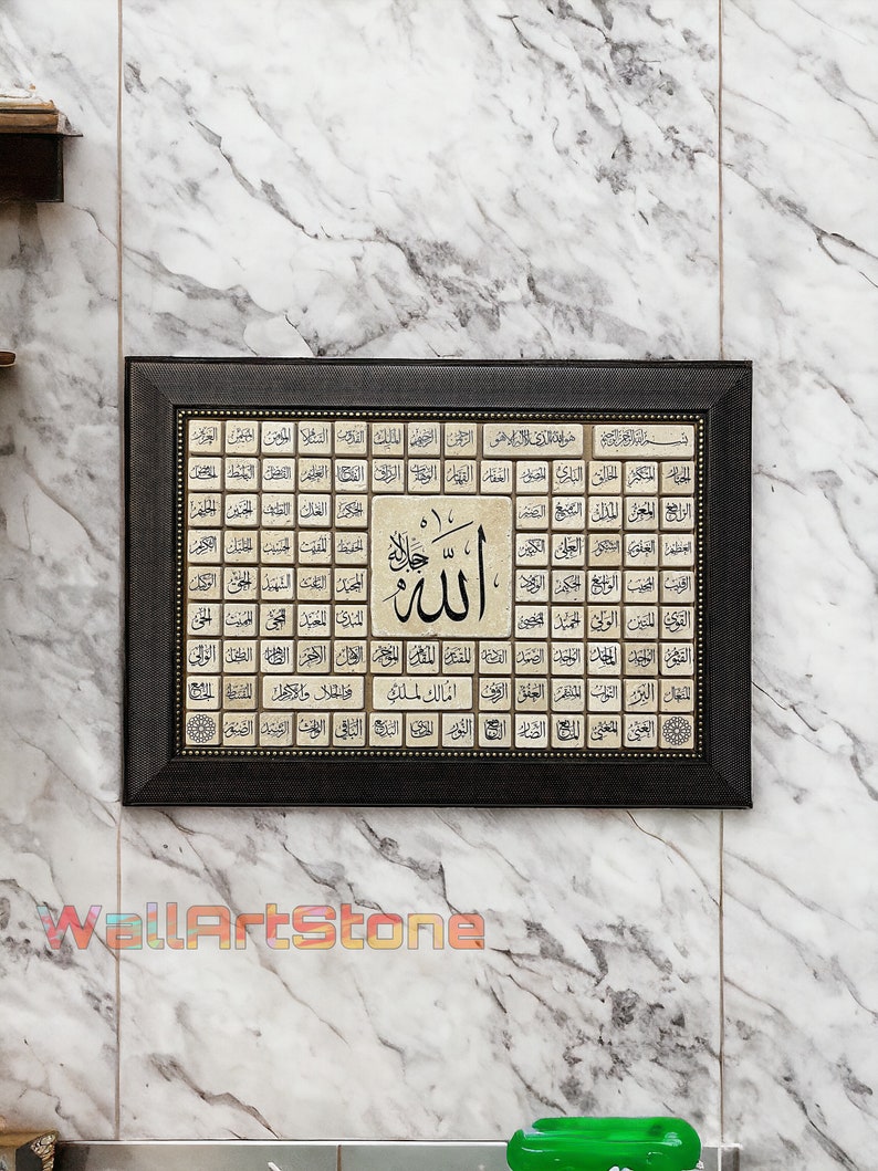 May include: A framed Islamic art print with a black frame and gold accents. The print features a large Arabic word "Allah" in the center surrounded by smaller Arabic words in a grid pattern.