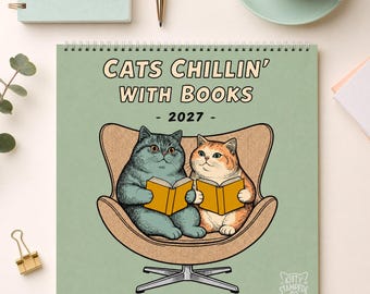 May include: A 2027 wall calendar with a light green cover featuring the text "CATS CHILLIN' WITH BOOKS". The illustration shows a grey cat and an orange tabby cat sitting in a tan armchair, each holding an open yellow book. The logo "KITTY STAMPEDE CO." is in the bottom right corner.