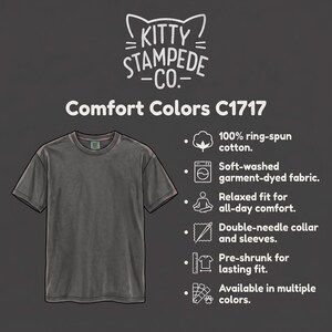 Pu&ograve; includere: Una t-shirt grigio antracite a maniche corte etichettata Comfort Colors C1717 di Kitty Stampede Co. Presenta 100% cotone ring-spun, tessuto tinto in capo lavato morbido, vestibilit&agrave; rilassata, colletto e maniche a doppio ago, pre-ristretto.