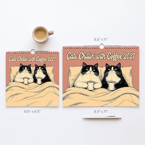 May include: Two wall calendars titled Cats Chillin' with Coffee 2027, featuring illustrations of two black and white cats in bed with mugs. One calendar is 8.5 by 8.5 inches, the other is 8.5 by 11 inches. A coffee mug and a silver pen are included.