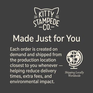 Puede incluir: Un gr&aacute;fico informativo gris oscuro con el texto blanco Kitty Stampede Co. y un icono de orejas de gato, la frase Made Just for You y un p&aacute;rrafo sobre producci&oacute;n bajo demanda. Un icono de globo terr&aacute;queo blanco dice Shipping Locally Worldwide.