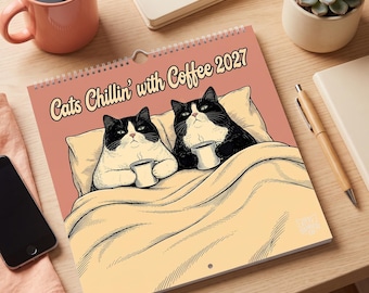 May include: A wall calendar titled Cats Chillin' with Coffee 2027 featuring a graphic illustration of two black and white tuxedo cats lying in bed under a yellow blanket, each holding a small white coffee mug against a dusty pink background.