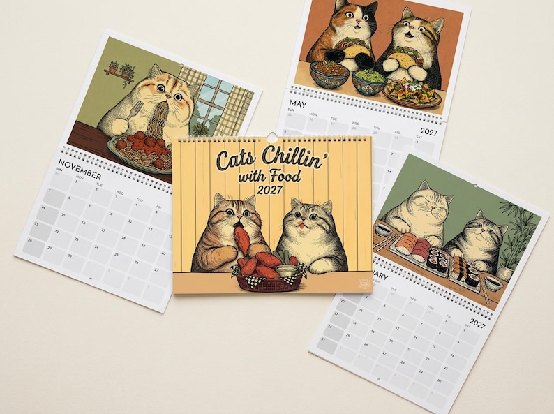 Puede incluir: Un calendario de pared 2027 titulado Cats Chillin' with Food con ilustraciones de gatos comiendo diversas comidas. La portada muestra dos gatos con pollo frito, mientras que las p&aacute;ginas interiores muestran gatos disfrutando de espaguetis, tacos y sushi.